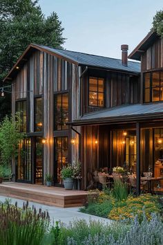 a large house with lots of windows and plants