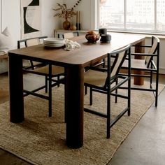 a dining room table with chairs and plates on it