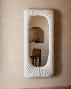 a mirror hanging on the wall above a chair