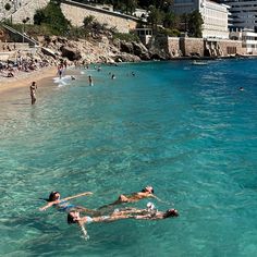 people are swimming in the clear blue water