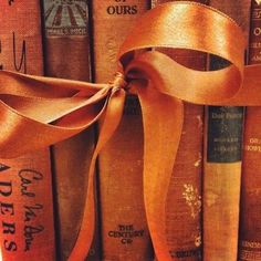 an orange ribbon tied on top of old books