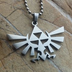 a silver necklace with an image of the legend of zelda on it