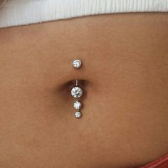 a woman's belly with three diamond studs attached to the back of her stomach