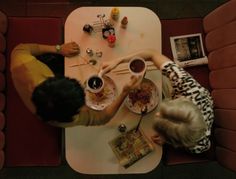 two people sitting at a table eating food