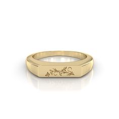 a yellow gold signet ring with an engraved design