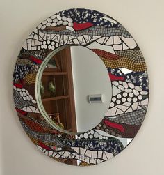 there is a mirror on the wall that has been made to look like a mosaic