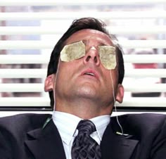 a man in a suit and tie with blindfolds on his eyes looking up