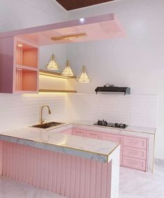 a kitchen with pink cabinets and marble counter tops in the center, along with an island