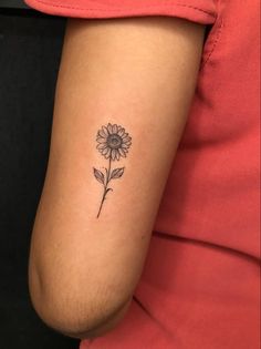 a small sunflower tattoo on the arm