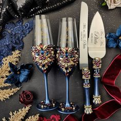 three wine glasses are decorated with jewels and ribbons next to a knife, flower bouquet, and ribbon