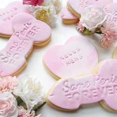 some pink cookies and flowers on a table