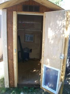 an outhouse with the door open and dog in it