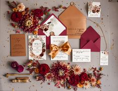 the wedding stationery is laid out with flowers, cards and envelopes for guests