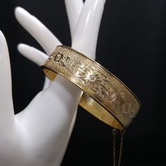 *Description: This is a beautiful floral hinged bracelet with individual flowers around the entire bracelet and it is stamped 10K GF from the 1930s.  The bracelet also has a mark under the plating mark but is unreadable.  The bracelet is 6 3/4 inches around the inside and 5/8 inch wide.  It has a push lock clasp and added safety chain. This would be a great addition to your vintage jewelry collection or make a great vintage gift! *Approximate Measurements: Length around inside: 6 3/4 Inches, Wid 1930 Jewelry, Individual Flowers, Jewelry Boards, Safety Chain, Hinged Bracelet, Gold Floral, Vintage Bracelets, Vintage Gifts, Gold Style