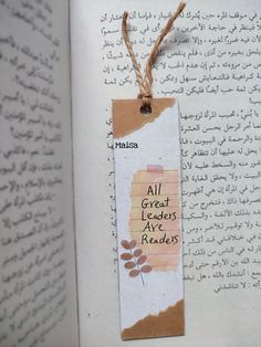 an open book with arabic writing on it and a paper tag attached to the page