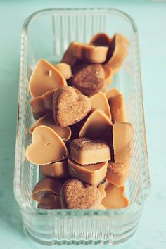 a glass container filled with lots of heart shaped candies on top of a table