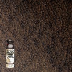 a bottle of alcohol sitting on top of a brown surface with rocks in the background