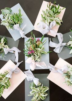 six different types of flowers tied together with white ribbons and bows on top of each other