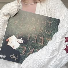 a woman holding up a book with the words we are gay written on it in front of her