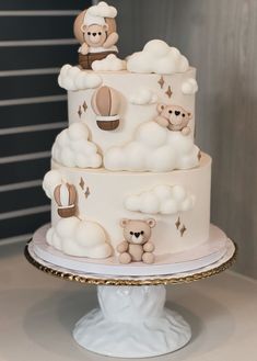 a three tiered cake with teddy bears on top