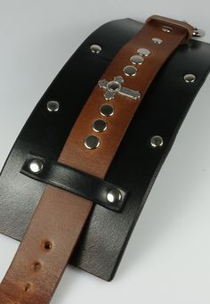 3" wide leather cuff made to resemble the same cuff worn by fictional character Merle Dixon. Center strap is 1" wide. - The cross is 1" long. - Solid brass buckle closure. - Brass rivets, nickel and chrome polish. Punk Leather Cuff Wristband, Edgy Leather Cuff Bracelet, Leather Punk Cuff Bracelet With Wrist Strap, Punk Leather Cuff Bracelet With Wrist Strap, Adjustable Leather Punk Cuff Bracelet, Leather Cuff Bracelet With Rivets, Adjustable Leather Gothic Wristband, Adjustable Gothic Leather Wristband, Merle Dixon