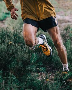 a man is running through the grass with his shoes on