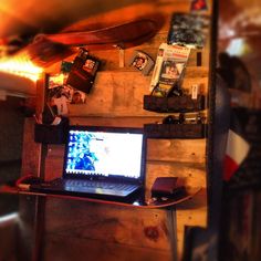 an open laptop computer sitting on top of a wooden desk next to a skateboard