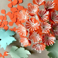 some orange and white paper flowers on a table