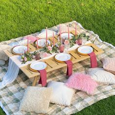 a picnic table set up with pink and white pillows