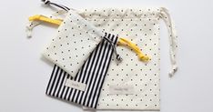 two bags with ties tied to them sitting next to each other on a white surface