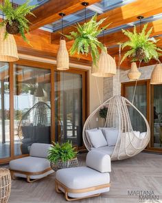 an outdoor living area with hanging plants and wicker furniture