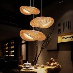 three lights hanging from the ceiling above a table in a room with chairs and tables