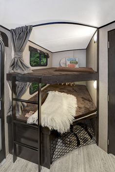 the inside of a travel trailer with a bunk bed and table in front of it