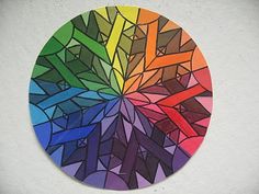 a multicolored circular design on a white wall