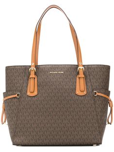 Timelessly elegant and surprisingly affordable, Michael Michael Kors collections capture the effortless, nonchalant finesse of the girl on the go. This brown leather Voyager tote bag features top handles, a front logo plaque, a monogram pattern, an internal zipped pocket, a logo printed lining, an internal slip pocket and an embossed internal logo stamp. | MICHAEL Michael Kors Voyager tote bag Bag Michael Kors, Monogram Pattern, Brown Tote, Michael Kors Collection, Iconic Bags, Crochet Bag Pattern, Logo Stamp, Perfect Bag, Handbags Michael Kors