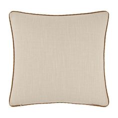 a beige pillow with brown piping on the front and bottom, sitting against a white background