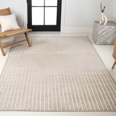 a large rug in the middle of a room with two wooden chairs and a window