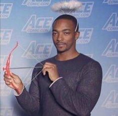 two men standing next to each other while holding scissors in front of their faces with hair on top of them