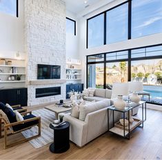 a living room filled with furniture and large windows