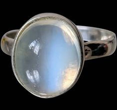 This is a stunning moonstone ring! It displays that rare, beautiful billowy light effect...that rare blue flash that so many of my customers covet, as well as myself. Moonstones are some of my most favorite gemstones in the world.  This is from the Edwardian era, or during the Arts and Crafts period. It boasts one large oval/round amazing, large moonstone!  Though you cannot give an exact carat weight for unfaceted gemstones, or cabashons, this, by my approximation is very close to six carats. The blue flash is amazing!  Set in Sterling Silver, I can definitely polish this piece for you, though many of my customers chose to keep that patina on, and I completely understand.  This piece is in excellent condition and is extremely comfortable on the hand!  Would make a wonderful alternative en Antique Moonstone Oval Cabochon Ring, Antique Collectible Moonstone Ring, Collectible Oval Cabochon Moonstone Ring, Antique Cabochon Moonstone Ring Gift, Antique Moonstone Ring, Oval Cabochon, Arts And Crafts Period, Alternative Engagement Rings, Edwardian Era, Moonstone Ring