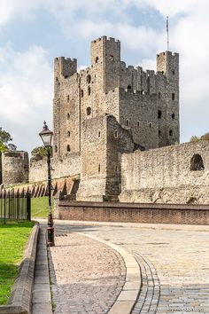 an old stone castle sitting on top of a lush green field