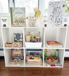 the shelves are filled with children's books and other items in front of a window