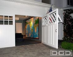 an american flag is hanging on the side of a white garage door that leads to a living room