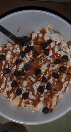 a bowl filled with ice cream, chocolate chips and marshmallows on top