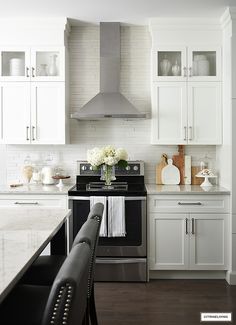 a kitchen with white cabinets and black appliances