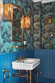 an image of a bathroom with blue and green wallpaper, gold fixtures and brass fixtures