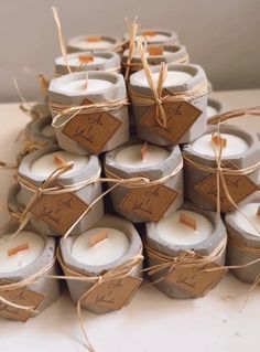 many candles are wrapped in twine and tied with brown paper, some have tags on them