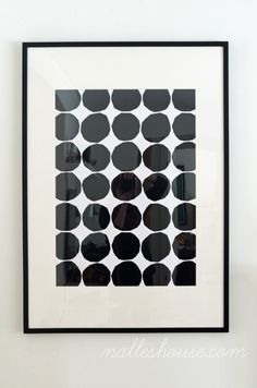 a black and white polka dot print hanging on the wall