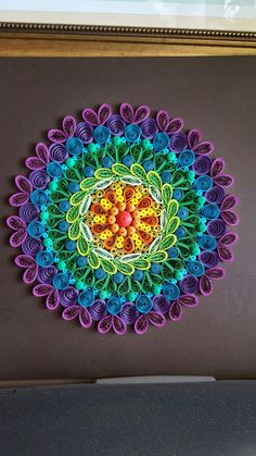 a colorful paper doily is displayed on the wall