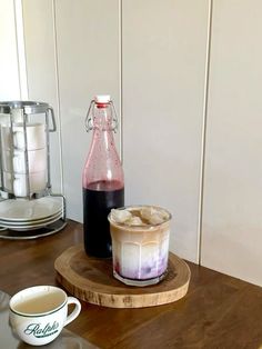 there is a drink and ice cream on the table next to the blender bottle